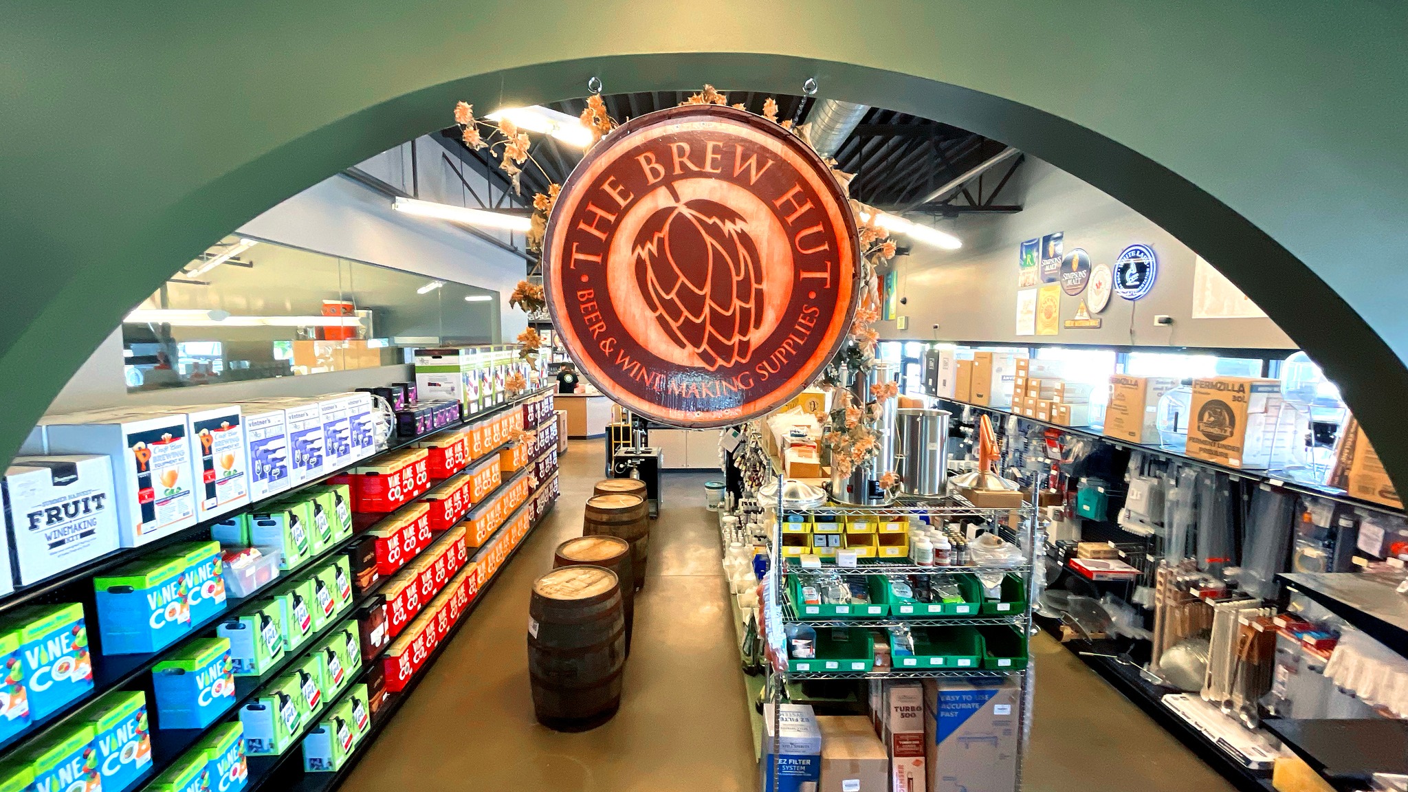 Entryway into The Brew Hut with small round wooden emblem with name and fully stocked supply shelves in the background