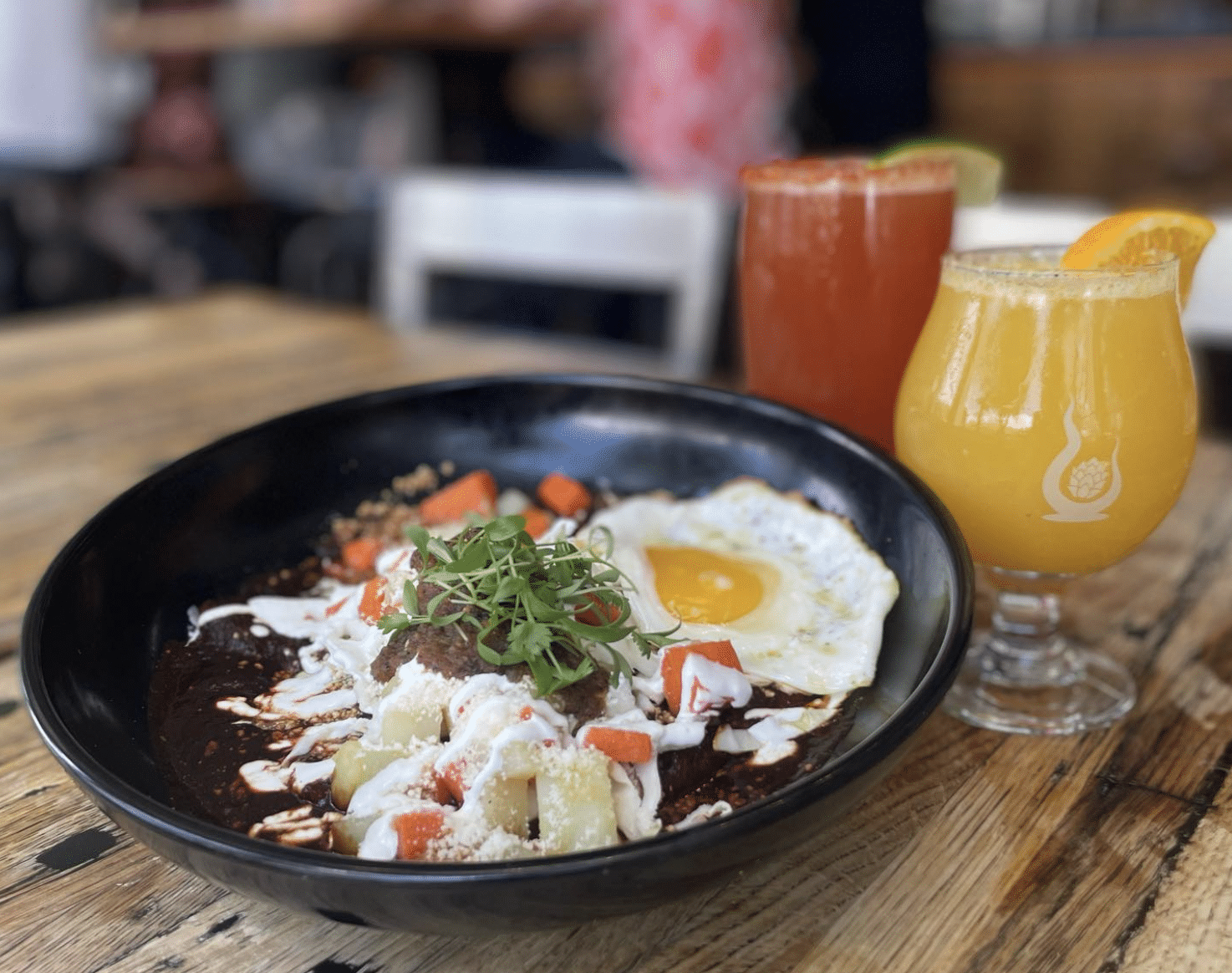 Black plate with eggs and vegetable scramble with 2 glasses of alcoholic beverages during brunch at Counter Culture Brewery + Grille in Denver