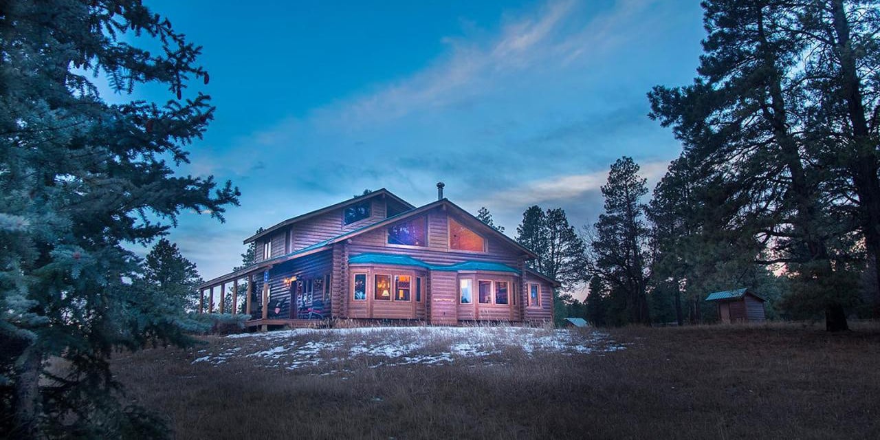 Evening exterior of the Elktrace Bed and Breakfast in Pagosa Springs, Colorado with some light snow on the ground