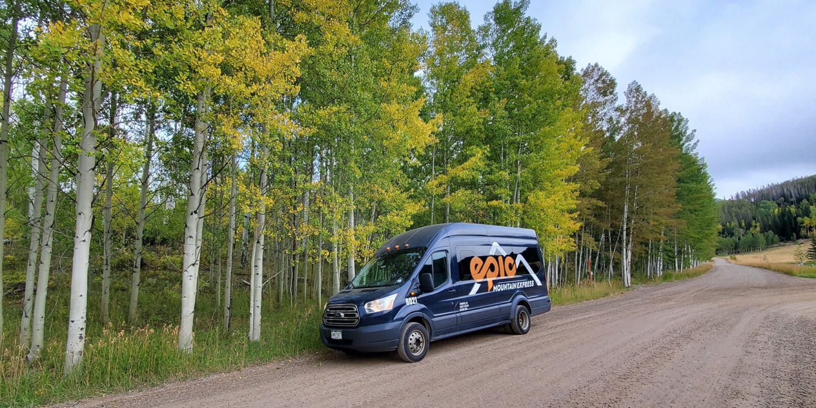 Black Epic Mountain Adventures van on a forest road