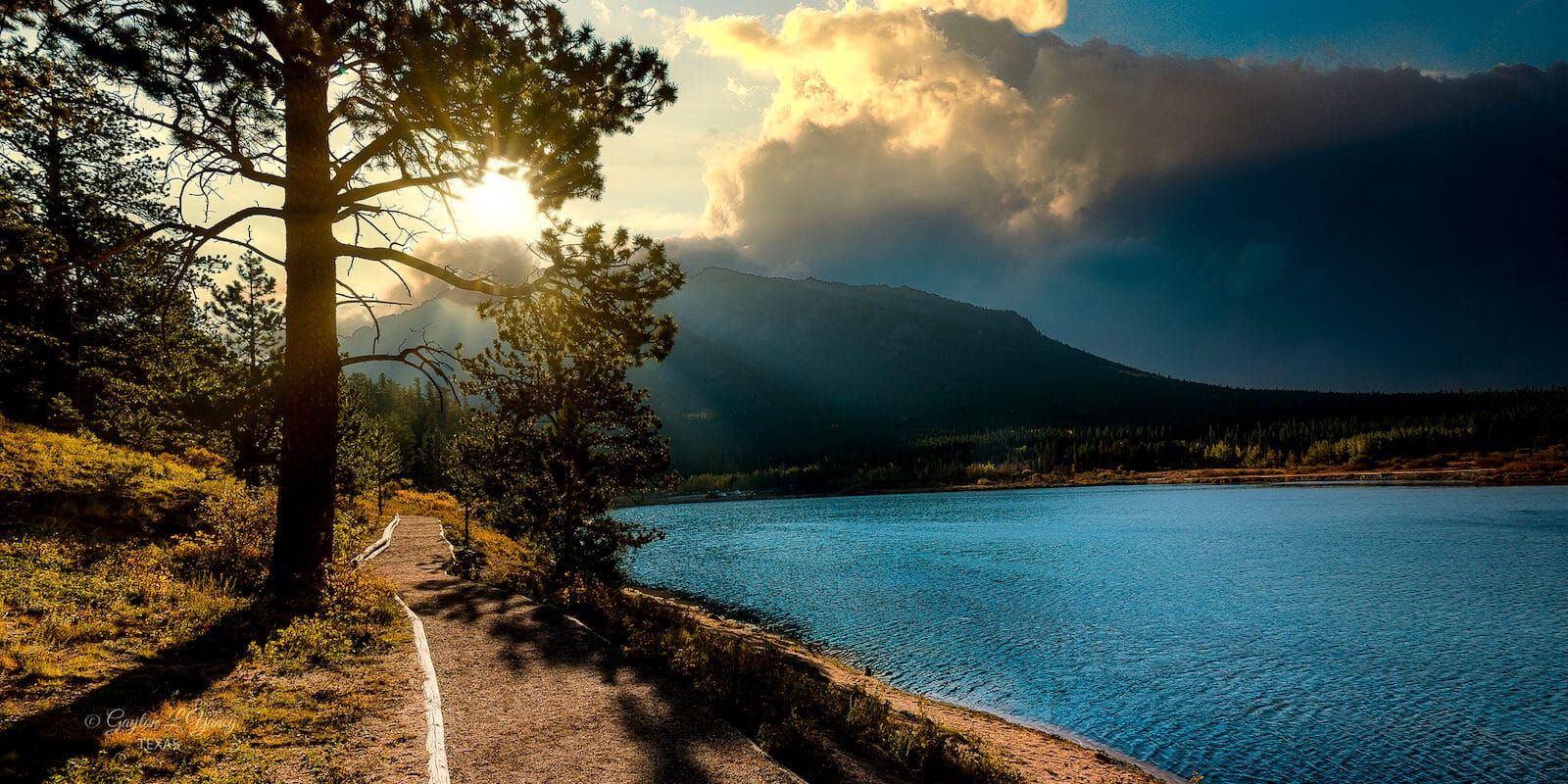 Sun shining above a mountain with clouds in the sky in Estes Park, Colorado