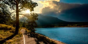 Sun shining above a mountain with clouds in the sky in Estes Park, Colorado