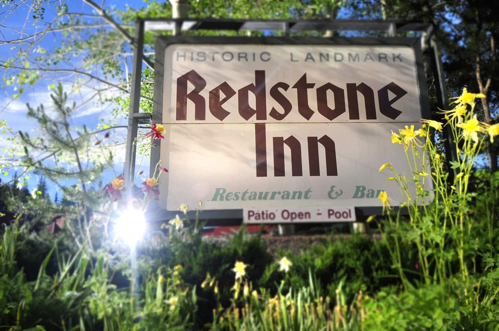 Large white sign with Redstone Inn in red lettering.