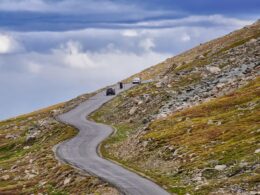 Car heading up Mt. Evans Byway with cloudy blue skies