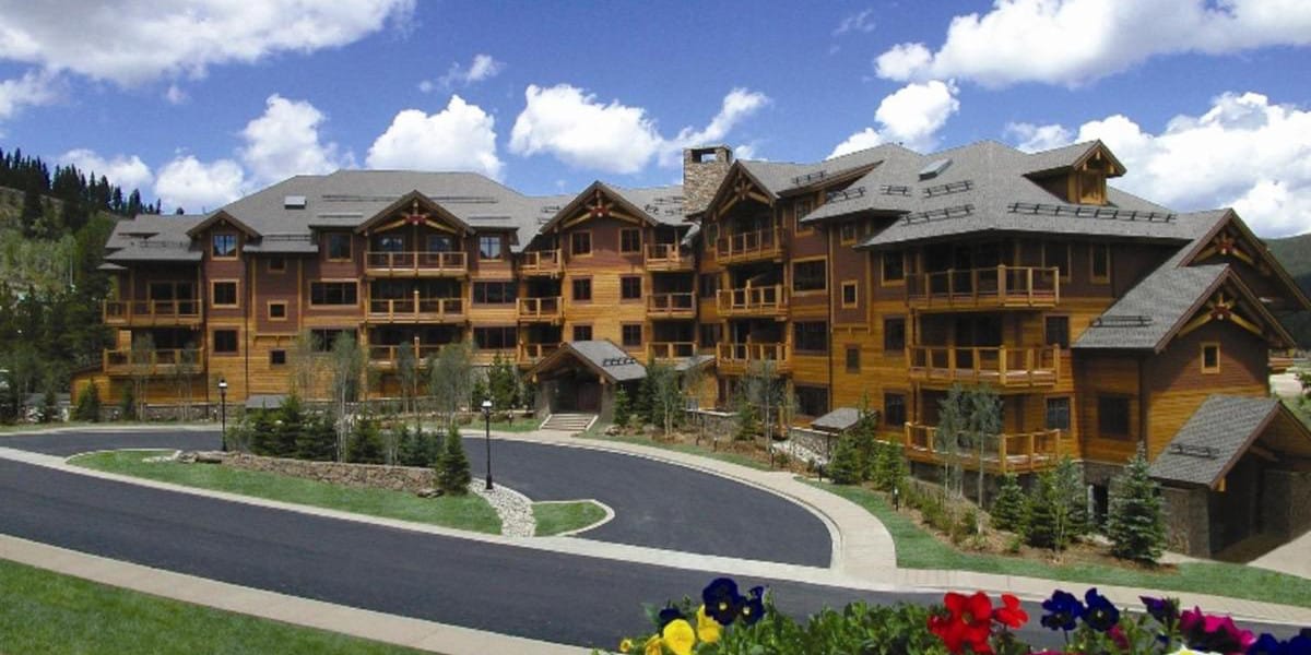 Exterior of Mountain Thunder Lodge, a wooden 4 story building with a semi-circle driveway in the front.