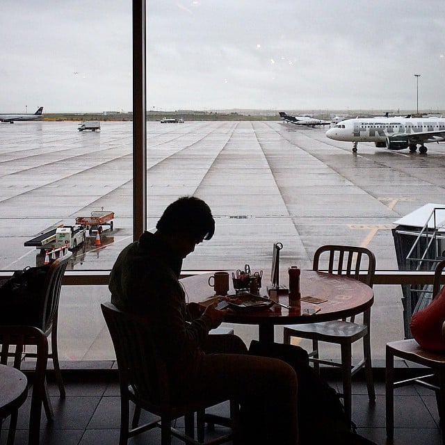 orang yang duduk di meja di Hub Belgia Baru di Bandara Internasional Denver