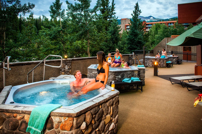 Three outdoor hot tubs at Beaver Run Resort with couples sitting in each one