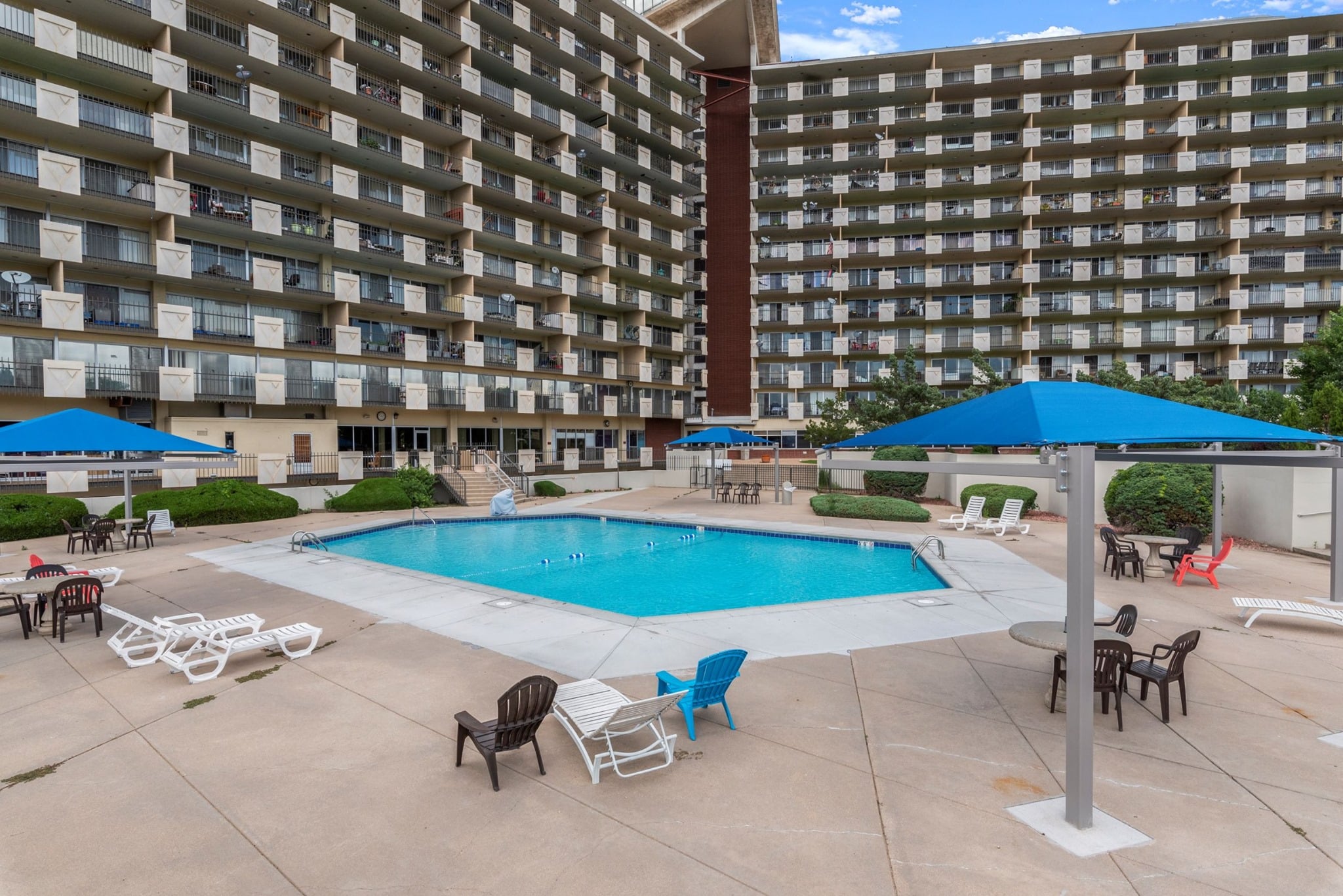 Outdoor hotel pool surrounded by large buildings at the Satellite Hotel