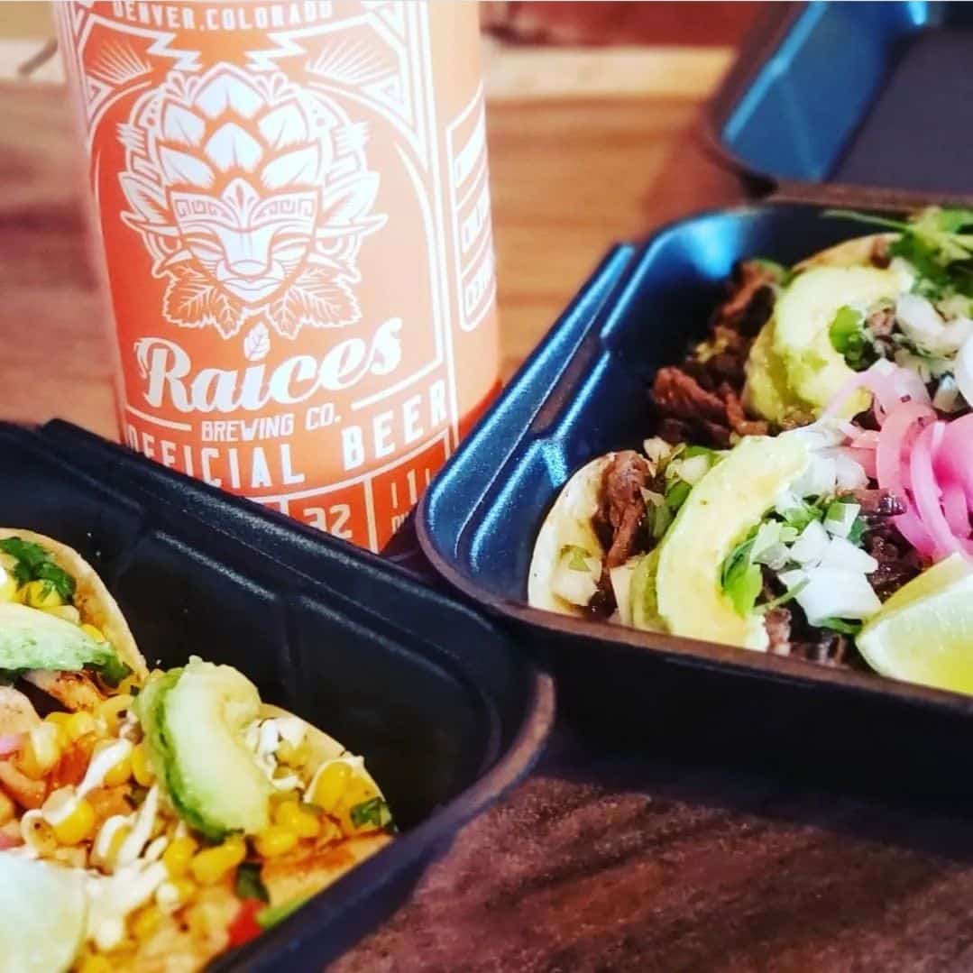 Two to-go containers of tacos with a peach colored can of Raices Brewing Co. beer in the middle