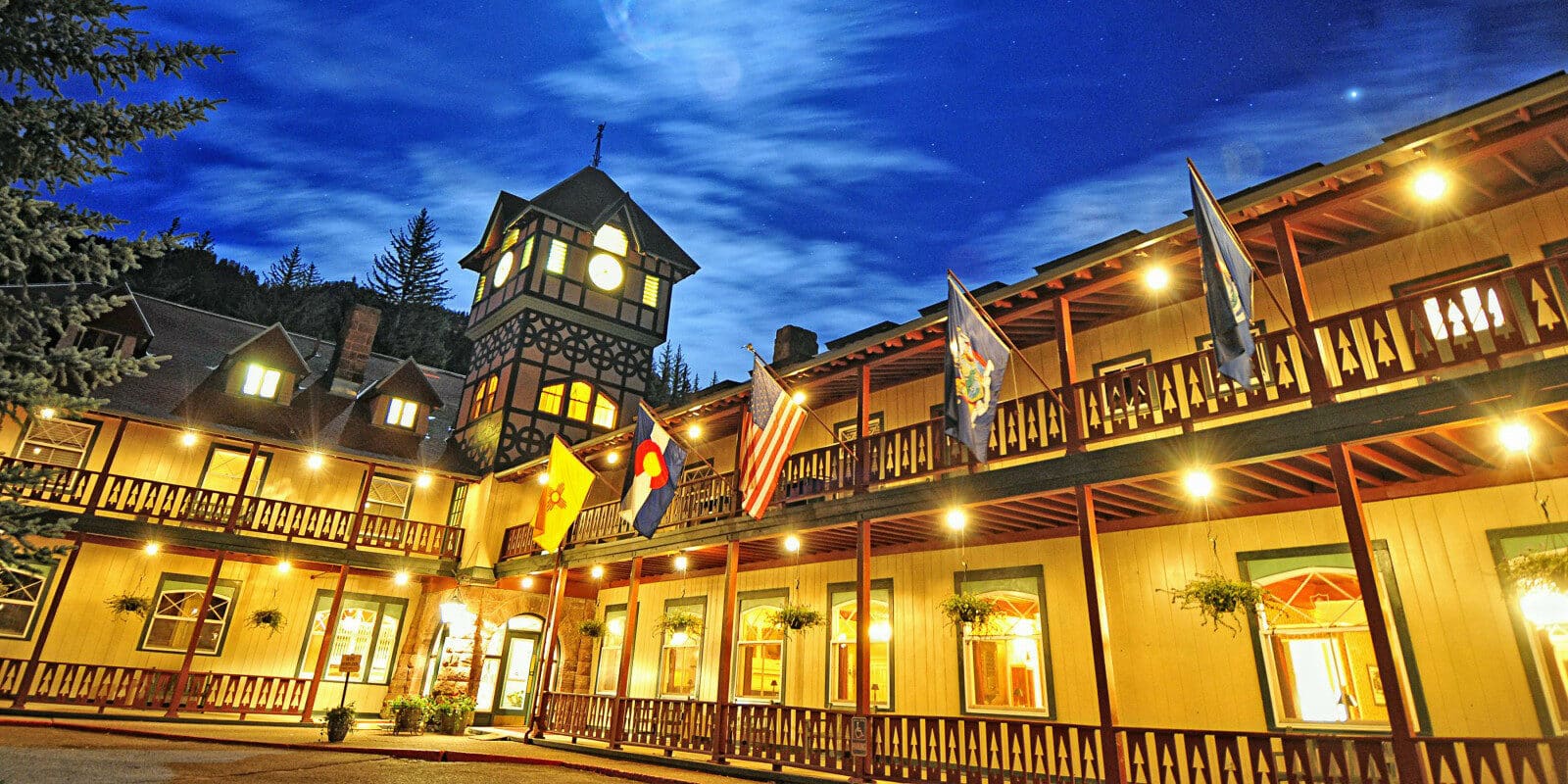 Moonlight shining over the Redstone Inn, a two story hotel building with a clocktower at the intersection of the two wings