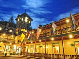 Moonlight shining over the Redstone Inn, a two story hotel building with a clocktower at the intersection of the two wings