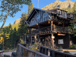 Exterior of Seven Keys Lodge on a blue skies day. Raised American flag above the building