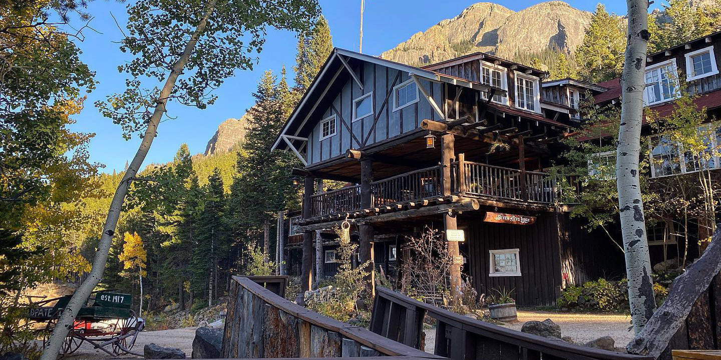 Exterior of Seven Keys Lodge on a blue skies day. Raised American flag above the building