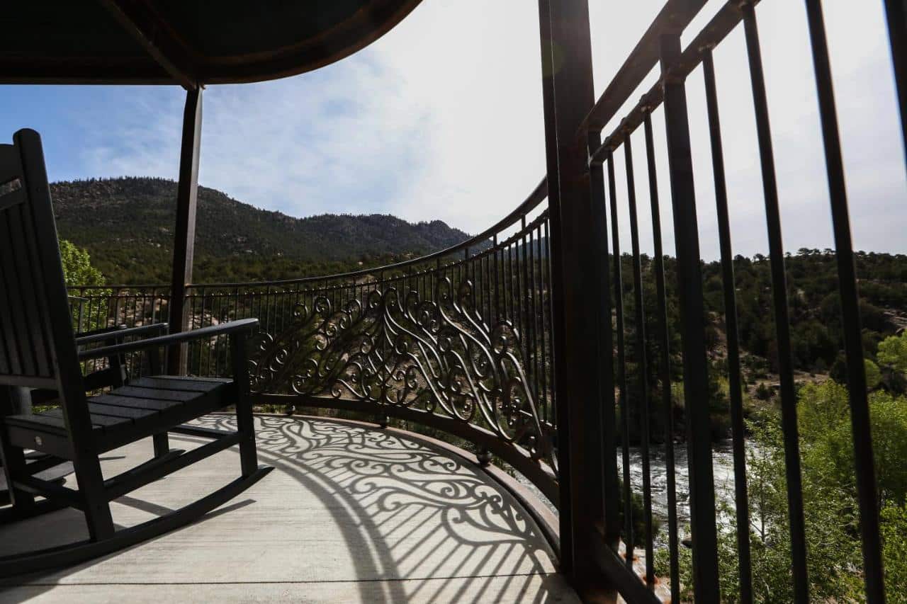 a rocking chair sits empty on the terrace of the Surf Hotel, overlooking the Arkansas River