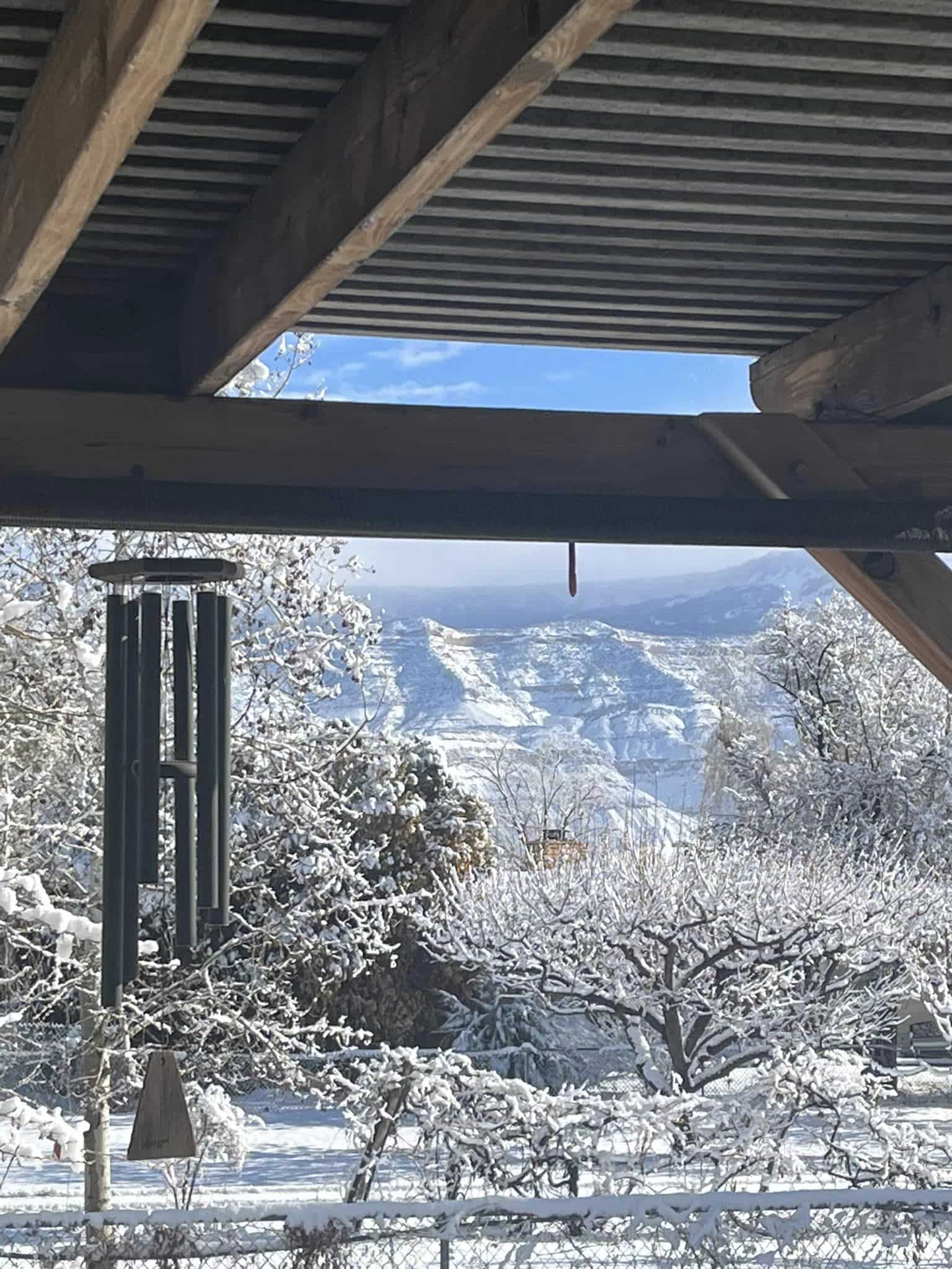 Windchime on the porch with a view of the Bookcliff Mountains in winter at Vistas & Vineyards BnB in Palisade, Colorado