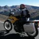 Motorcycle rider on yellow bike cruising along a high elevation road in Rocky Mountain National Park in central Colorado