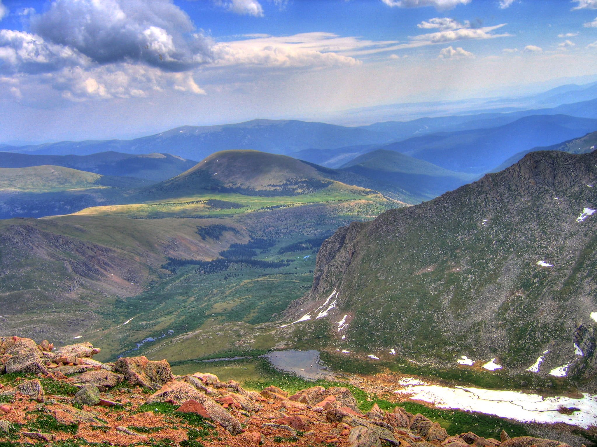 Views from near the top of the Mount Evans Scenic Byway. Pictured is a sweeping view of rolling green mountains