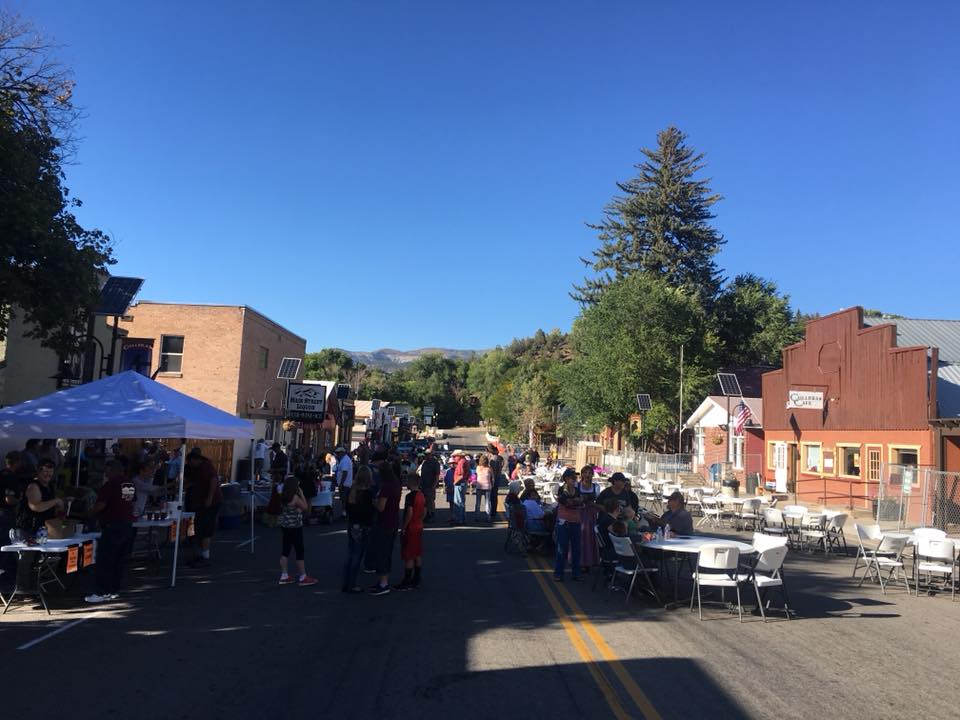 Main Street of Collbran with a few white tents and plastic tables set up for the Oktoberfest event