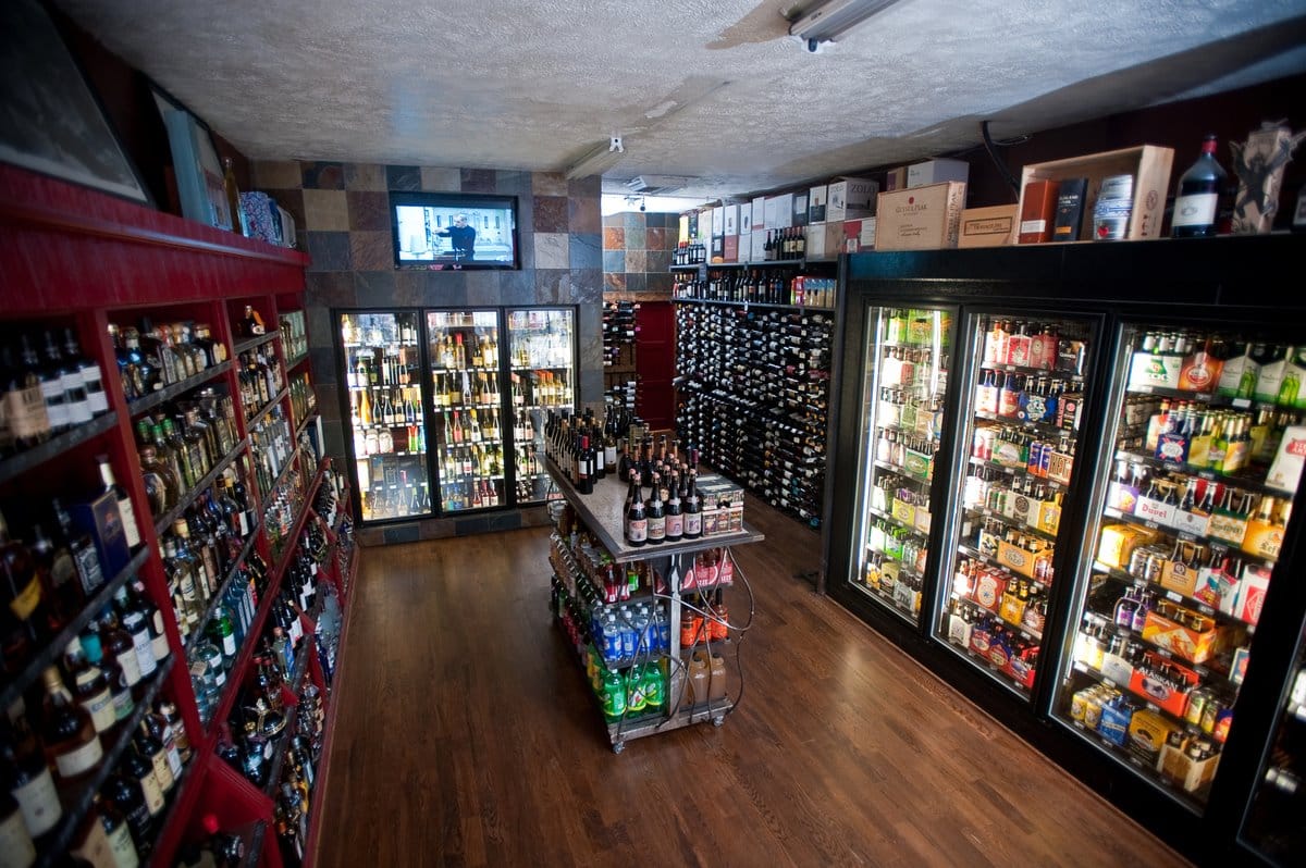 Interior of Toast! Wine and Spirits in Denver. Somewhat small room with freezers on the right and back walls and racks of alcohol on the left. 