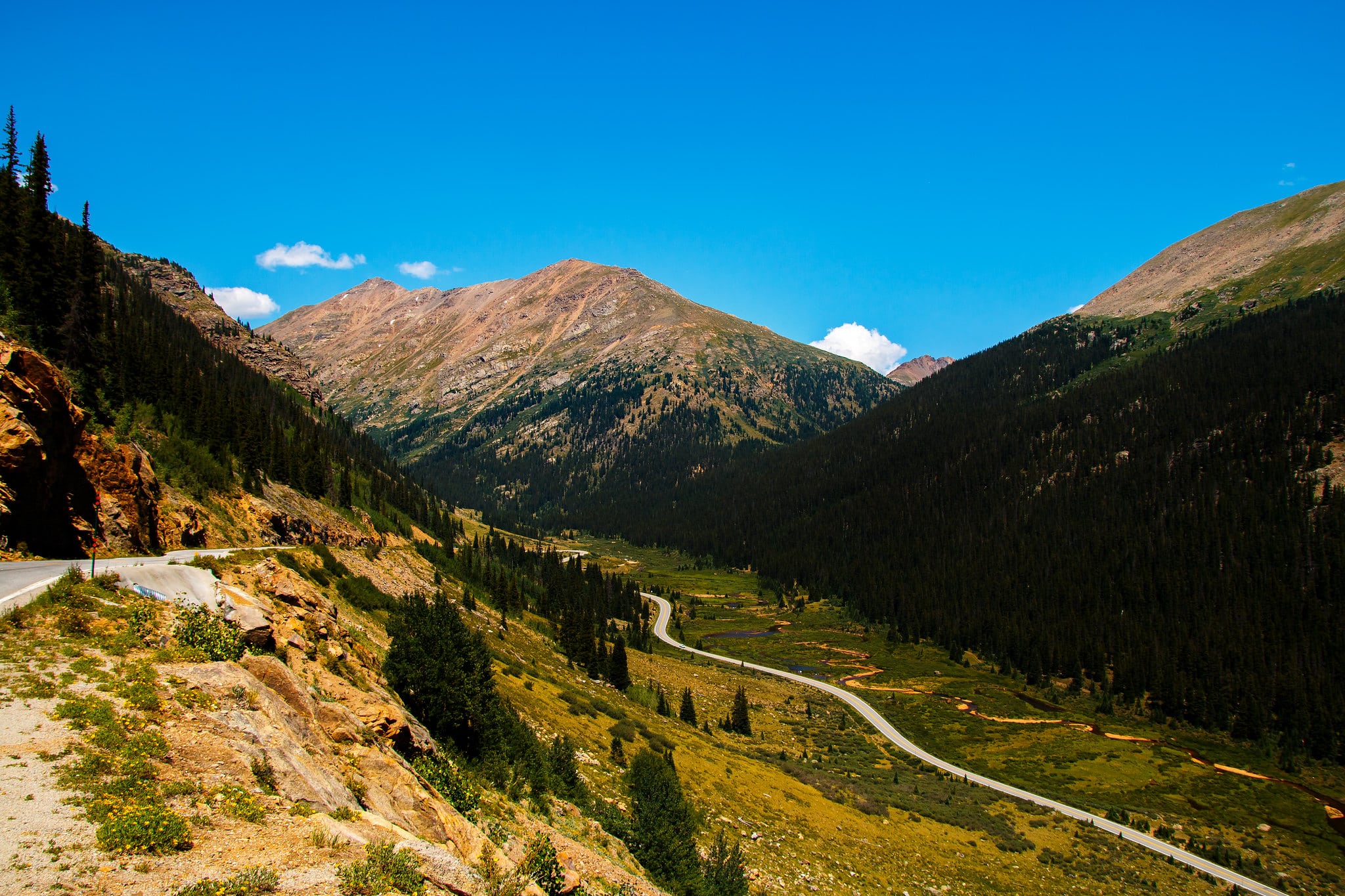 Winding Independence Pass highway through a valley of green mountains on the Top of the Rockies Byway.