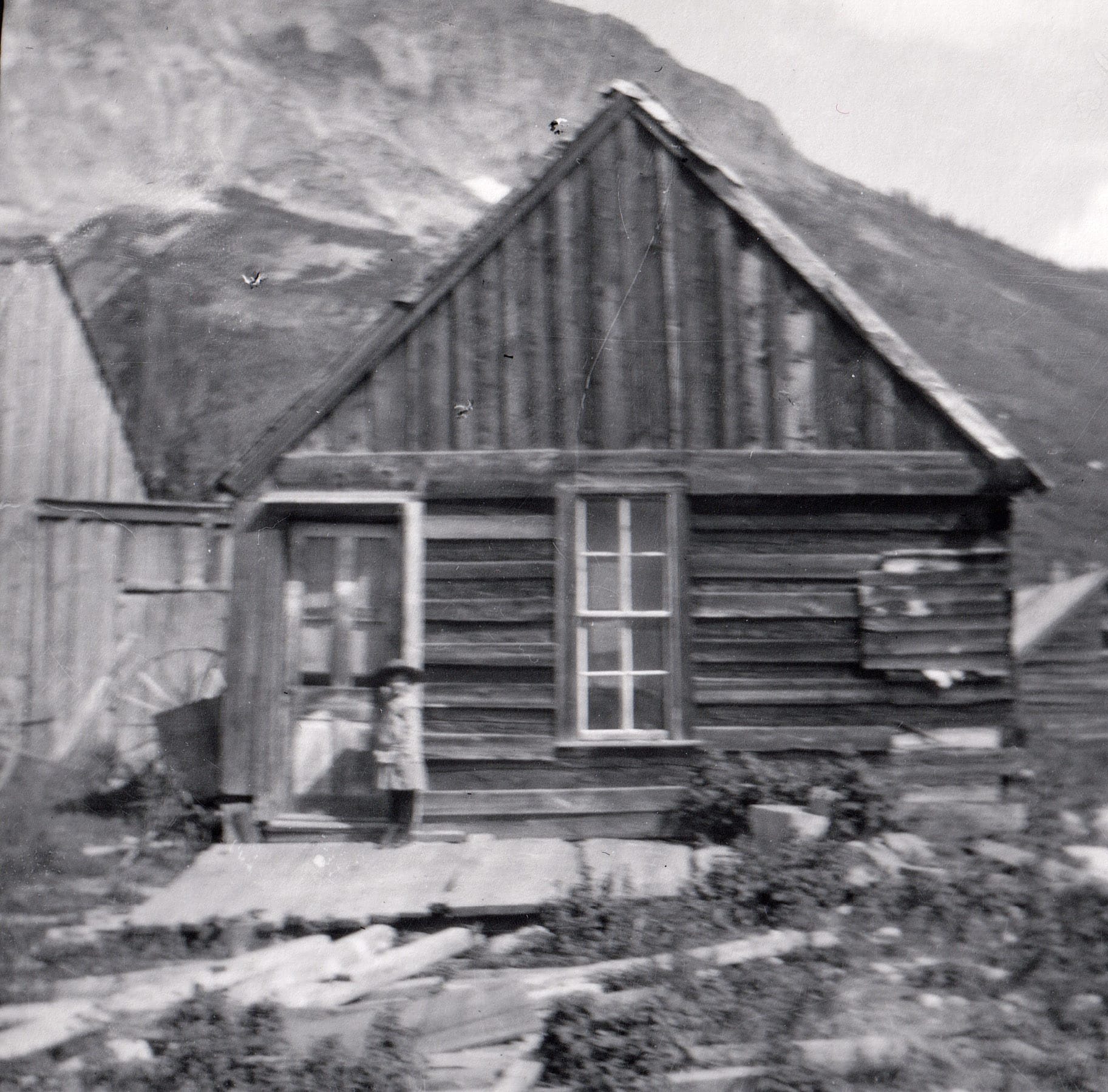 black and white photo of child standing outside her home on porch in 1915 in Gothic, Colroado