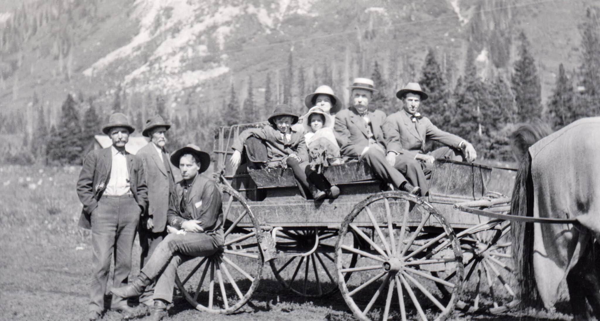 A family poses for a photo in 1915 sitting and standing beside a wagon in Gothic, Colroado