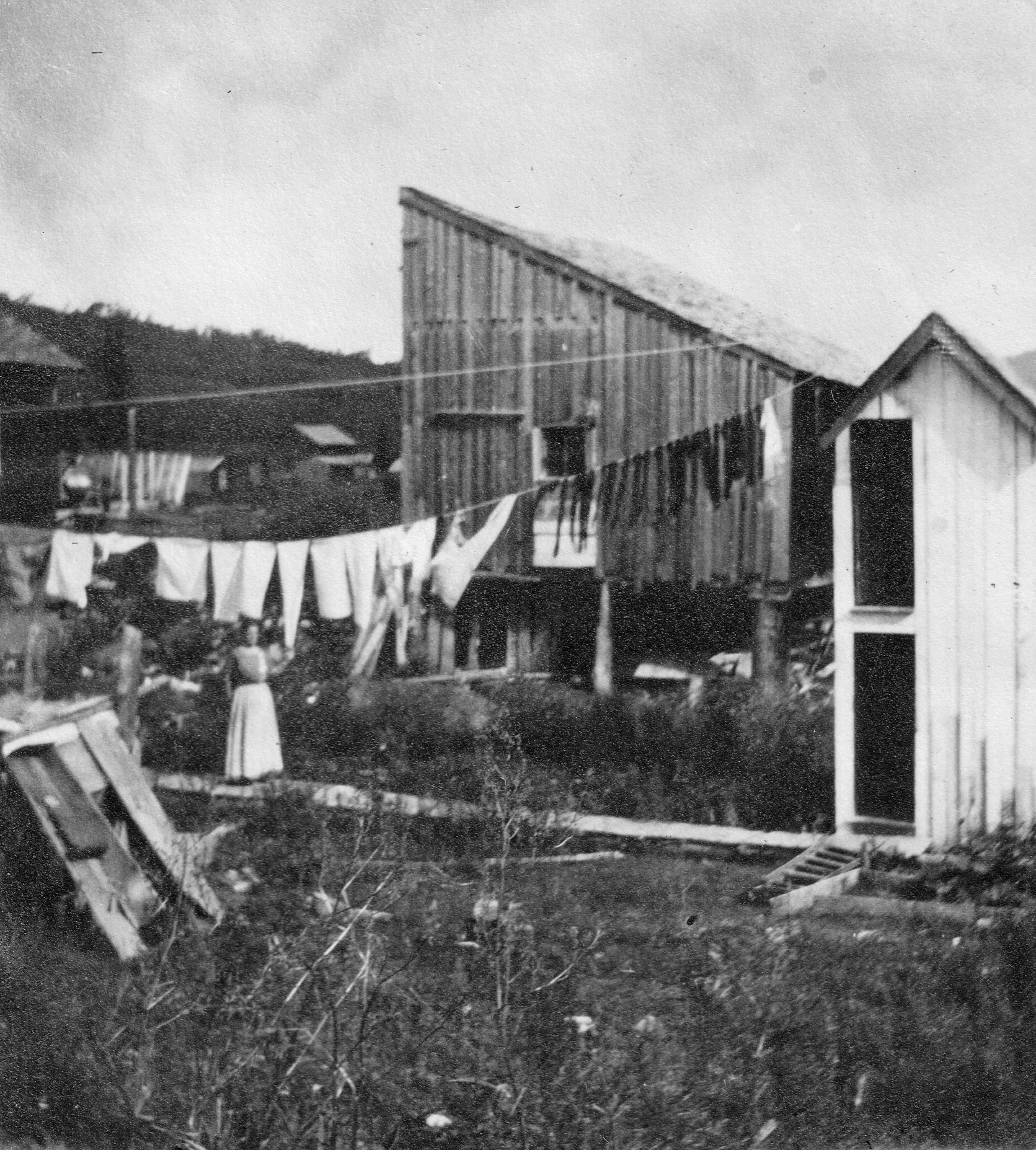 black and white photo of woman outside hanging clothes in 1913 in Gothic, Colorado