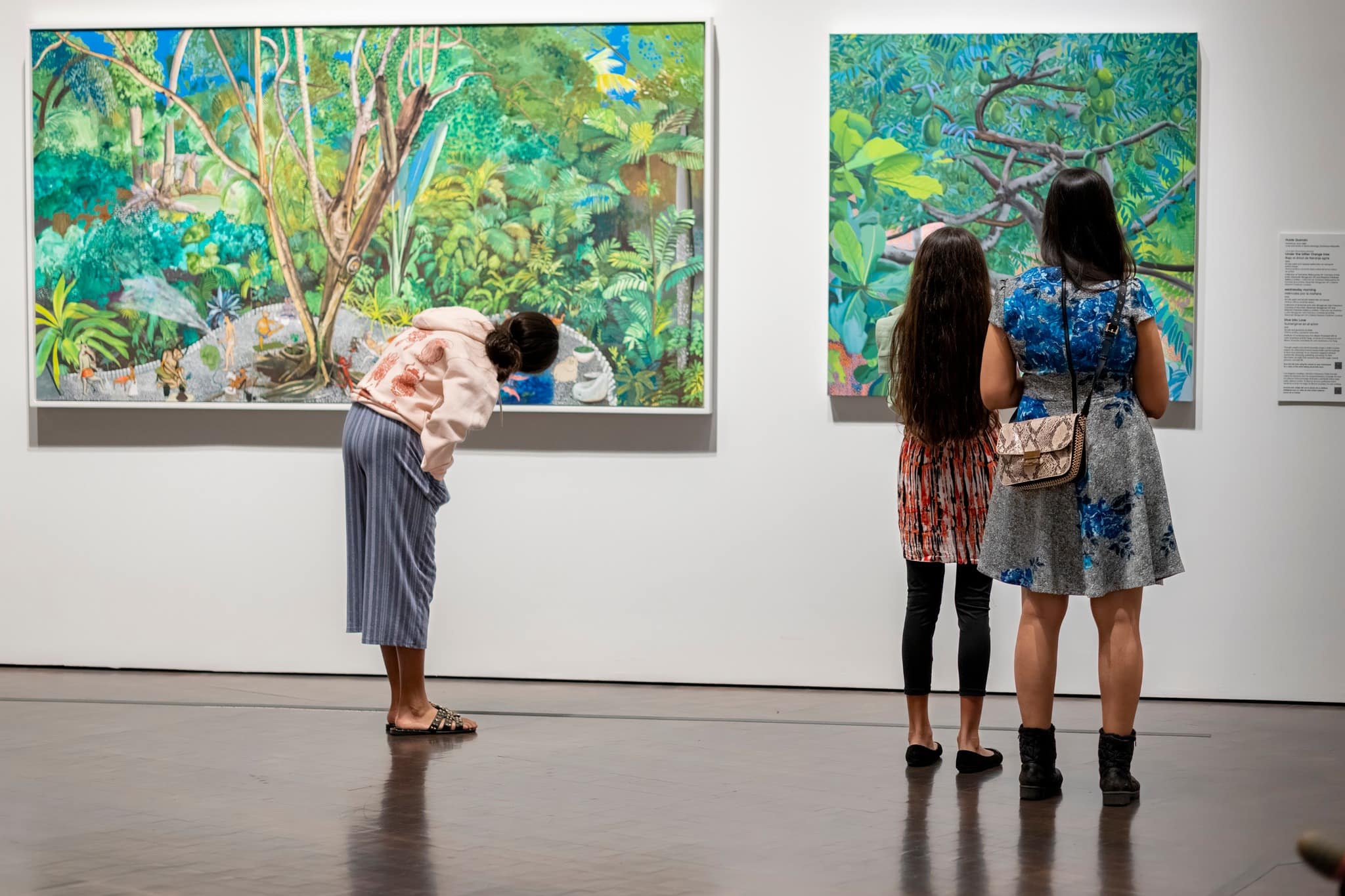 Three people standing in front of 2 paintings at the Denver Art Museum