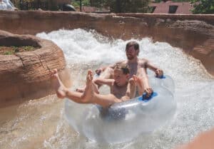 Father and kid slider down a tube on the Shoshone Chutes at Glenwood Hot Springs