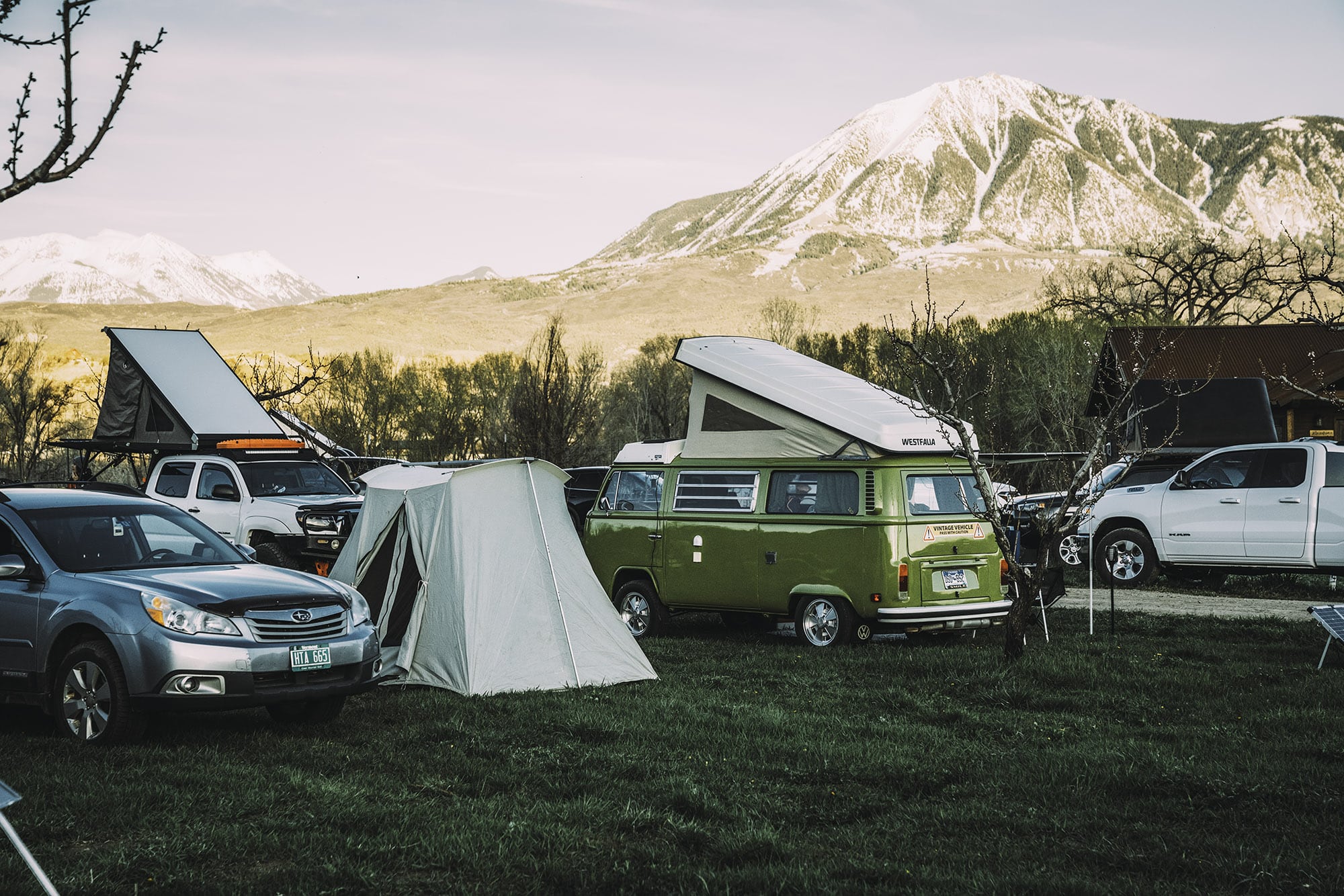 Tent and van campers at HESTIVAL in Hotchkiss with snow-capped mountains in background