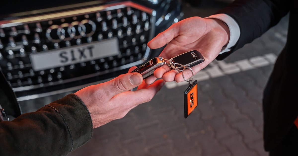 2 hands exchange a set of Audi keys for SIXT car rental