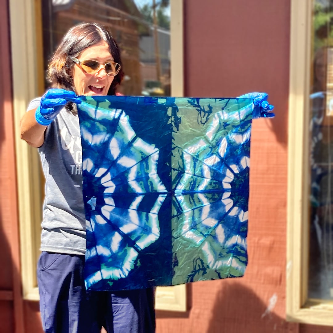 Woman holding up a tie dye bandana at Rocky Mountain Folk School in Grand Lake, Colorado
