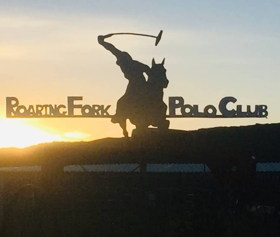 Roaring Fork Polo Club sign with sun setting in distance