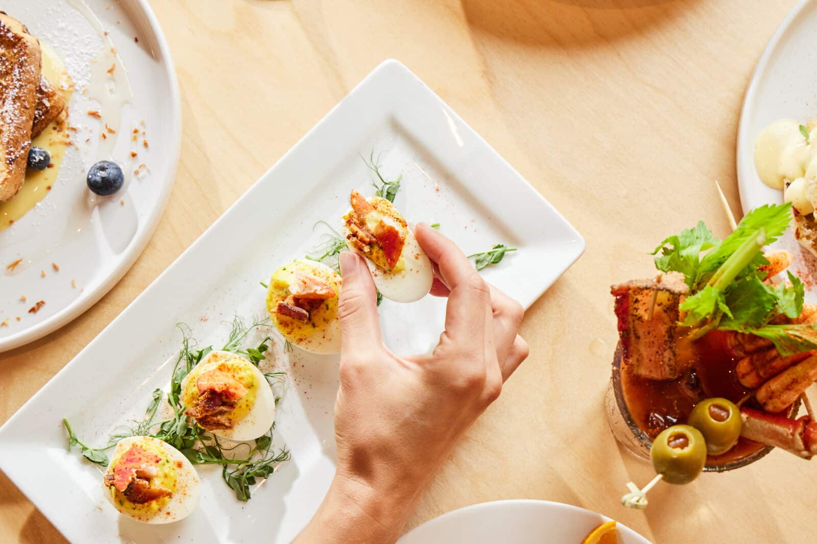 Close up deviled eggs with lobster and a bloody mary at Jax Fix House in Denver