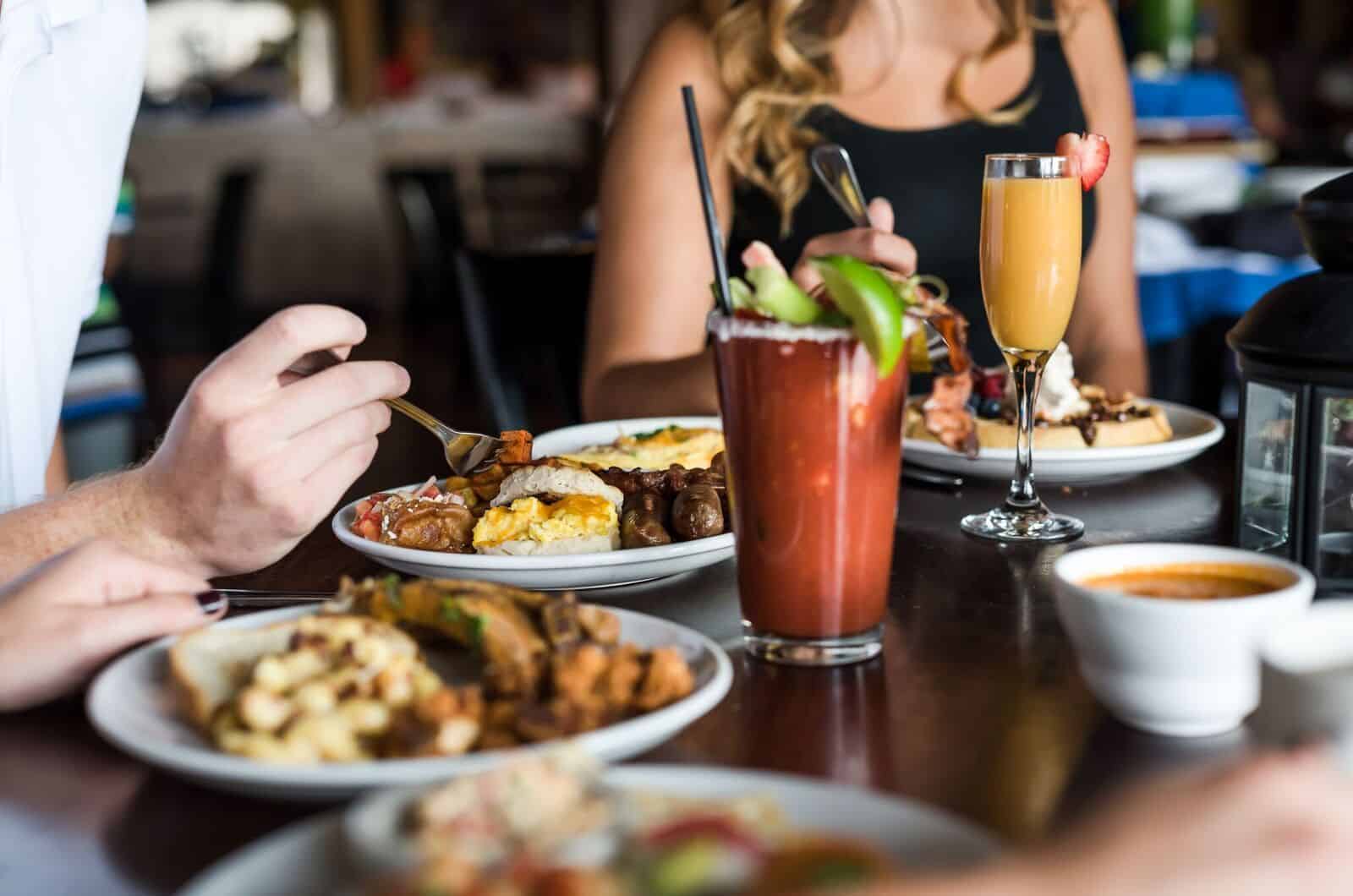 close up of people eating brunch with a bloody mary