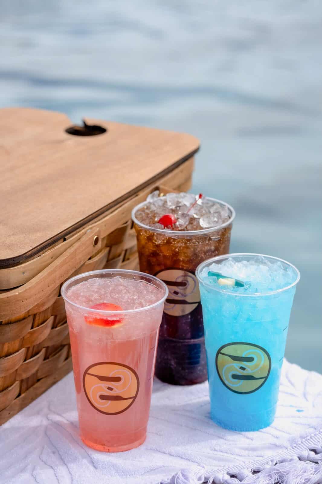 3 Ziggi's Coffee Dirty Soda sit by a picnic basket by the pool