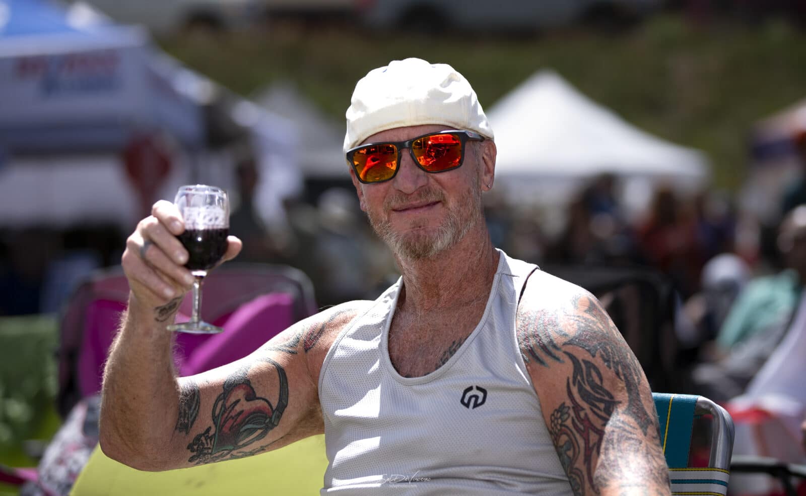 man raises a red wine glass at Nederland Jazz & Wine Festival