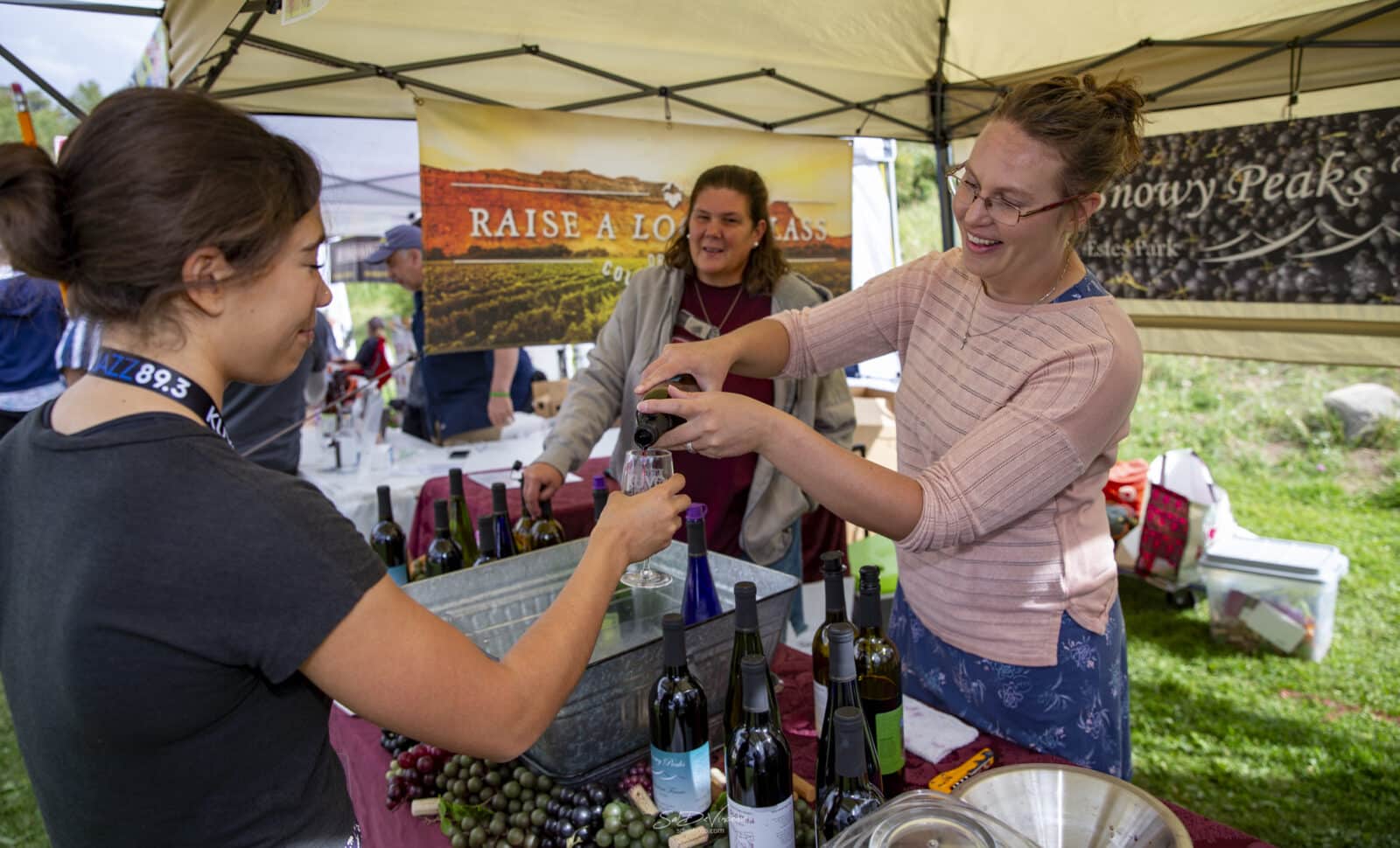 Woman fills up another lady's wine glass at the Nederland Jazz & Wine Festival