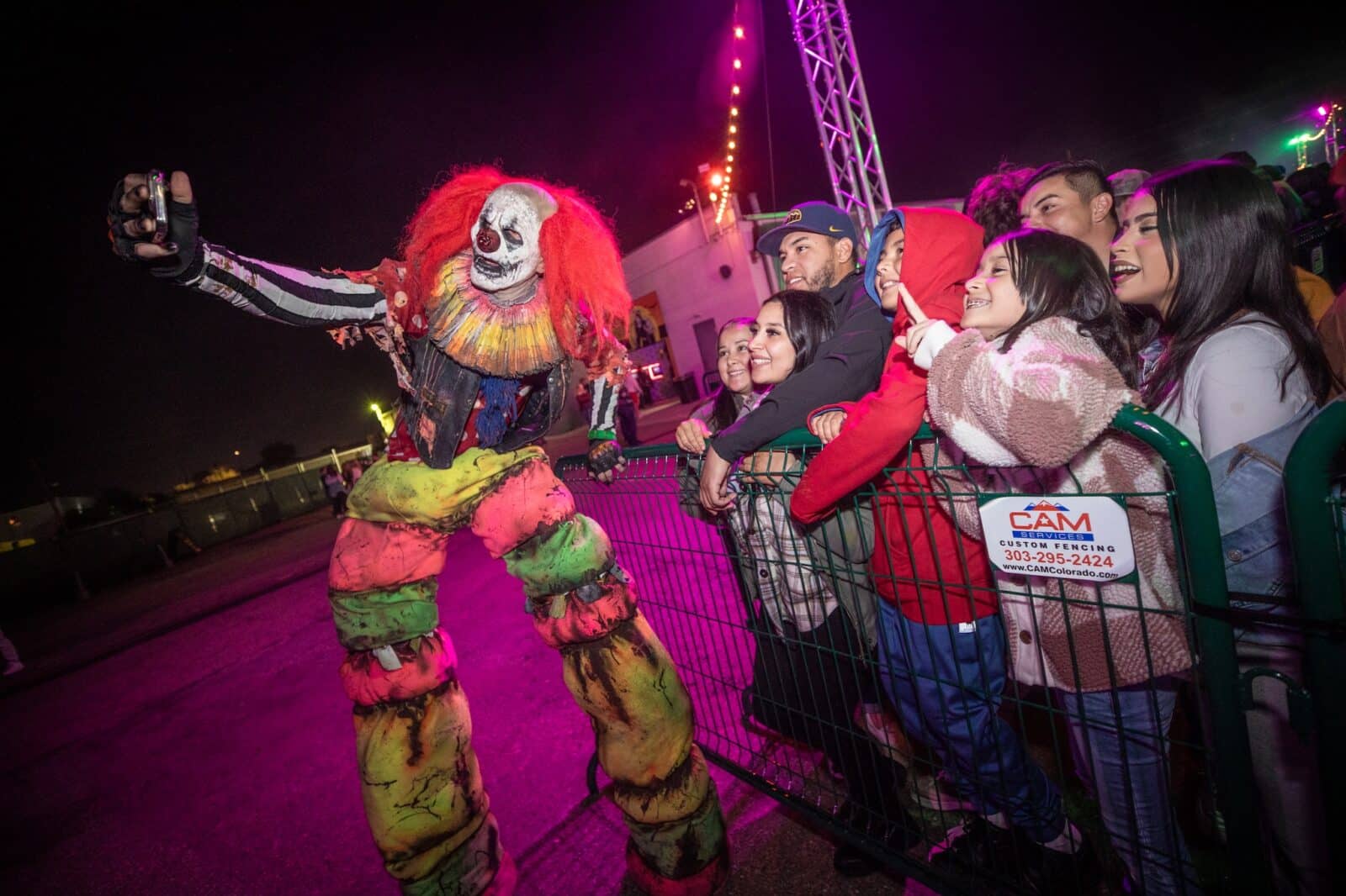 scary clown taking selfie with group at 13th Floor Haunted House in Denver
