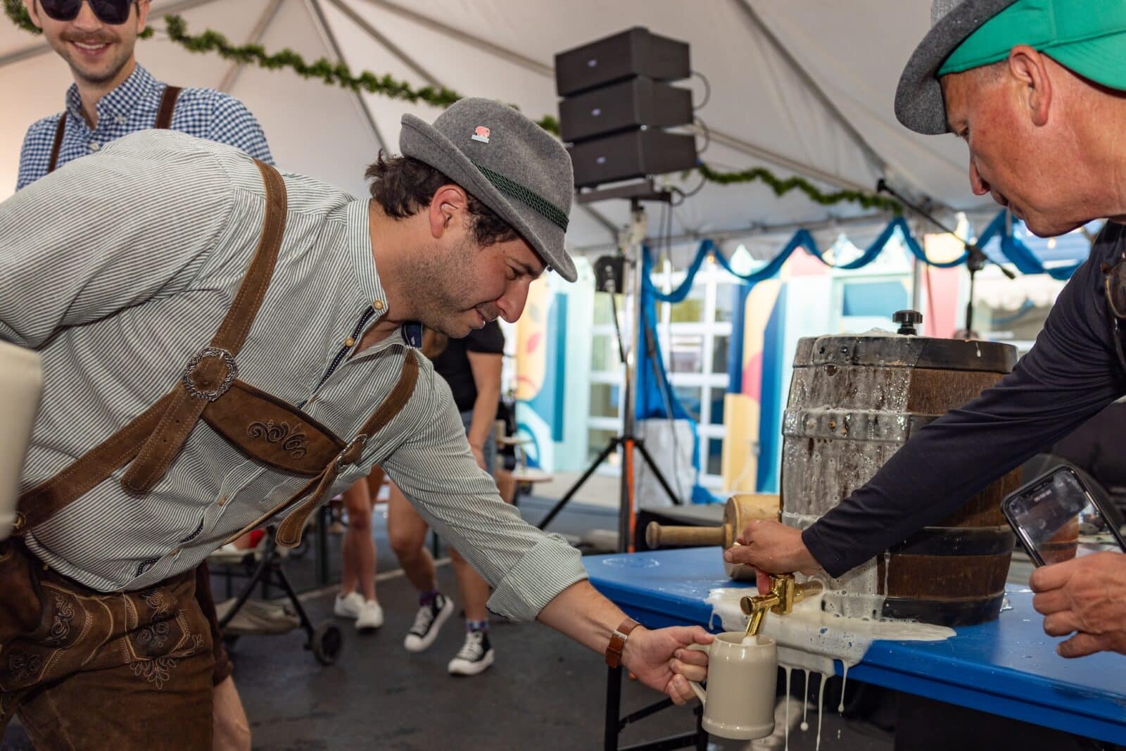 man in lederhosen fills up beer stein at Highlands Oktoberfest