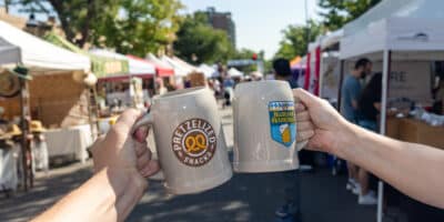 two people cheers beer steins at the Highlands Oktoberfest