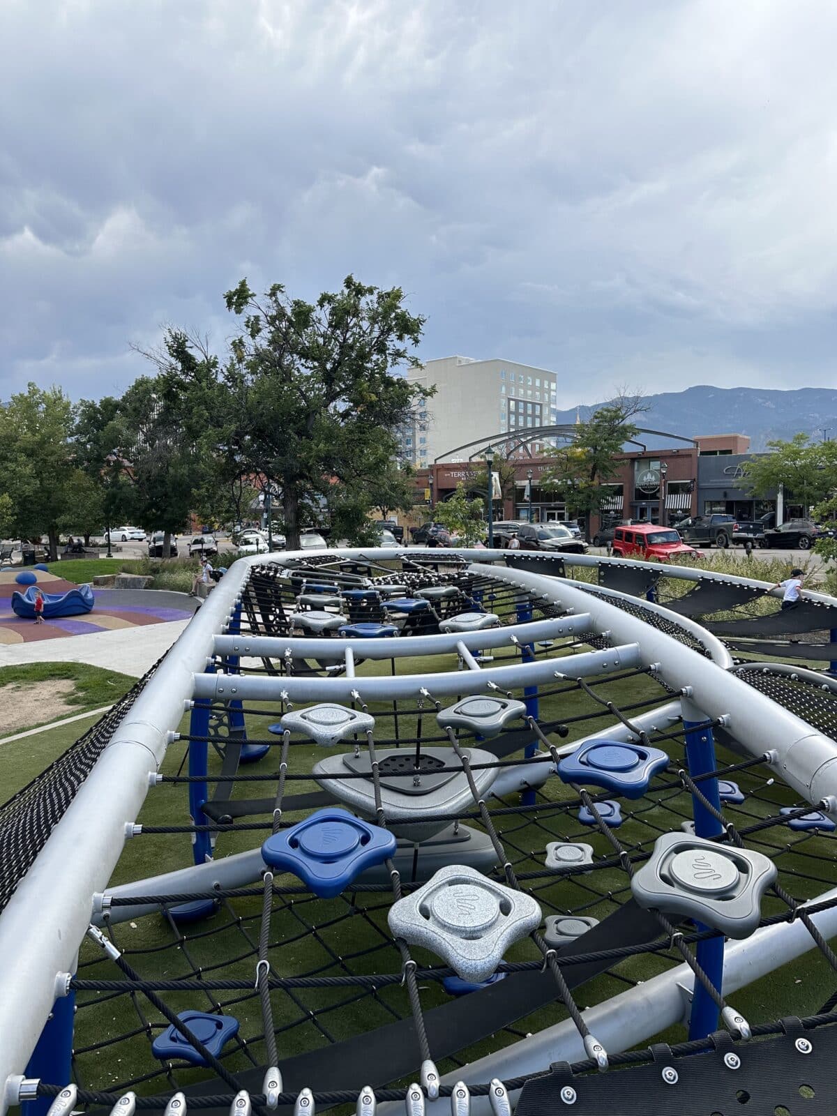 View from the top of the playground in Acacia Park with downtown Colorado Springs and mountains in background