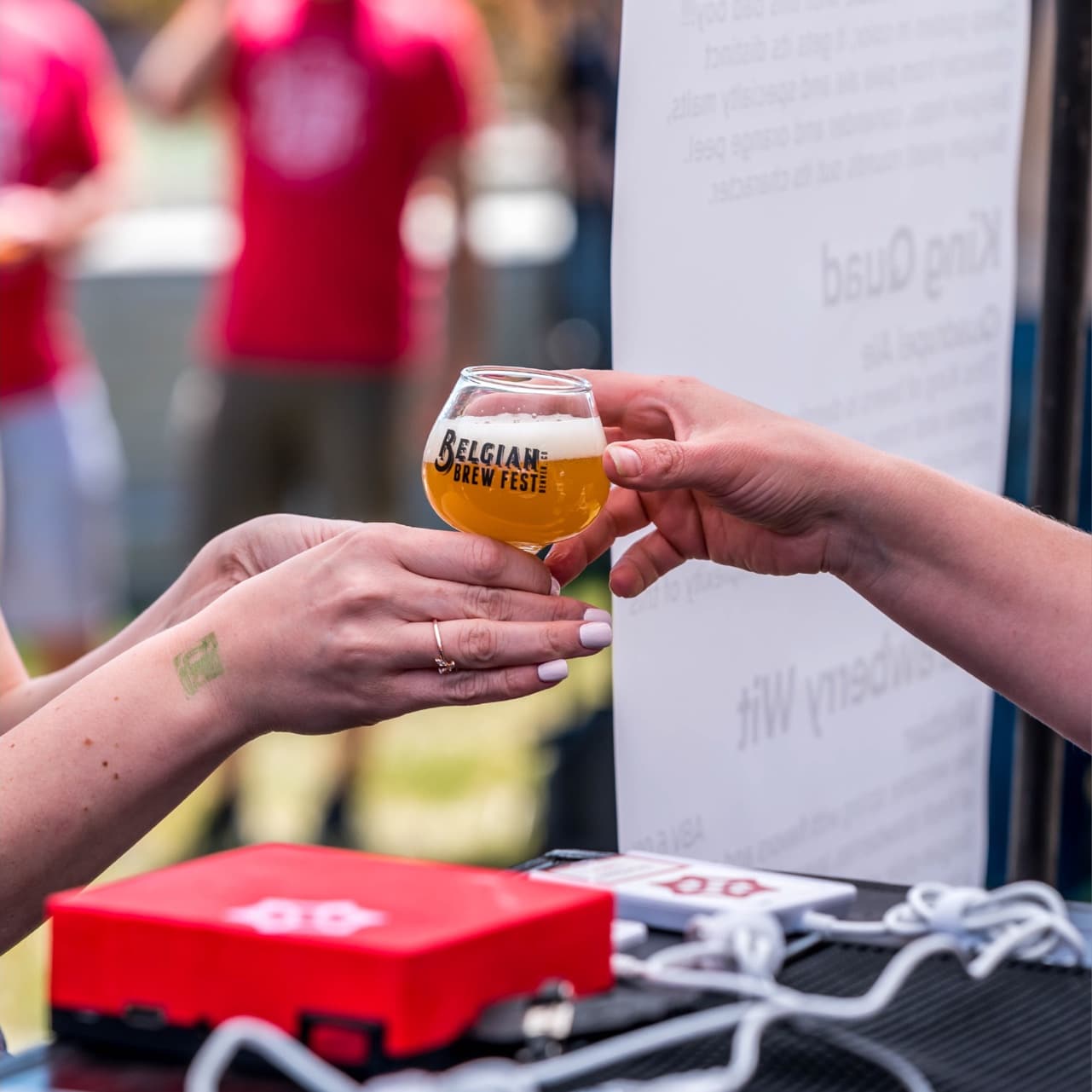 bartender hands Belgian Brew Fest logo glass with beer to customer