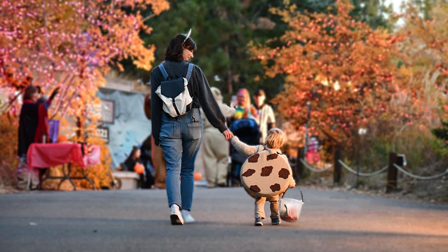Mom and son hold hands while trick or treating at Boo at the Zoo in Colorado Springs