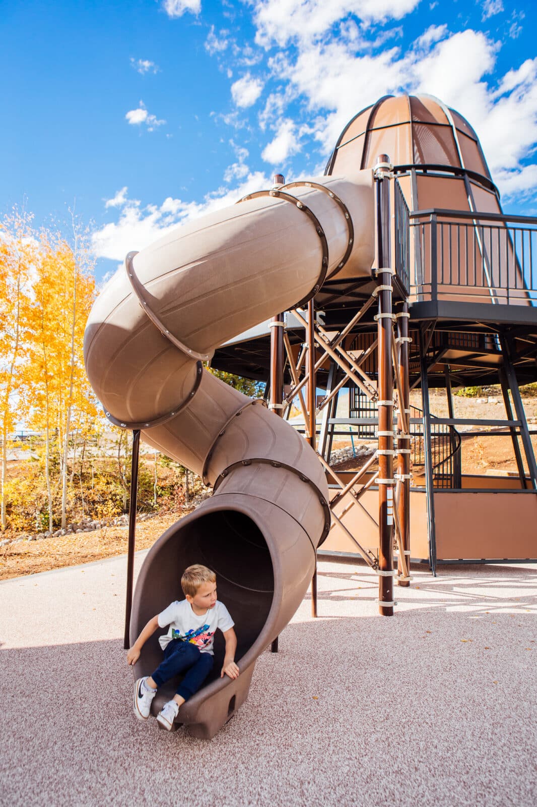 boy at the bottom of a slide at Idlewild Park in Winter Park