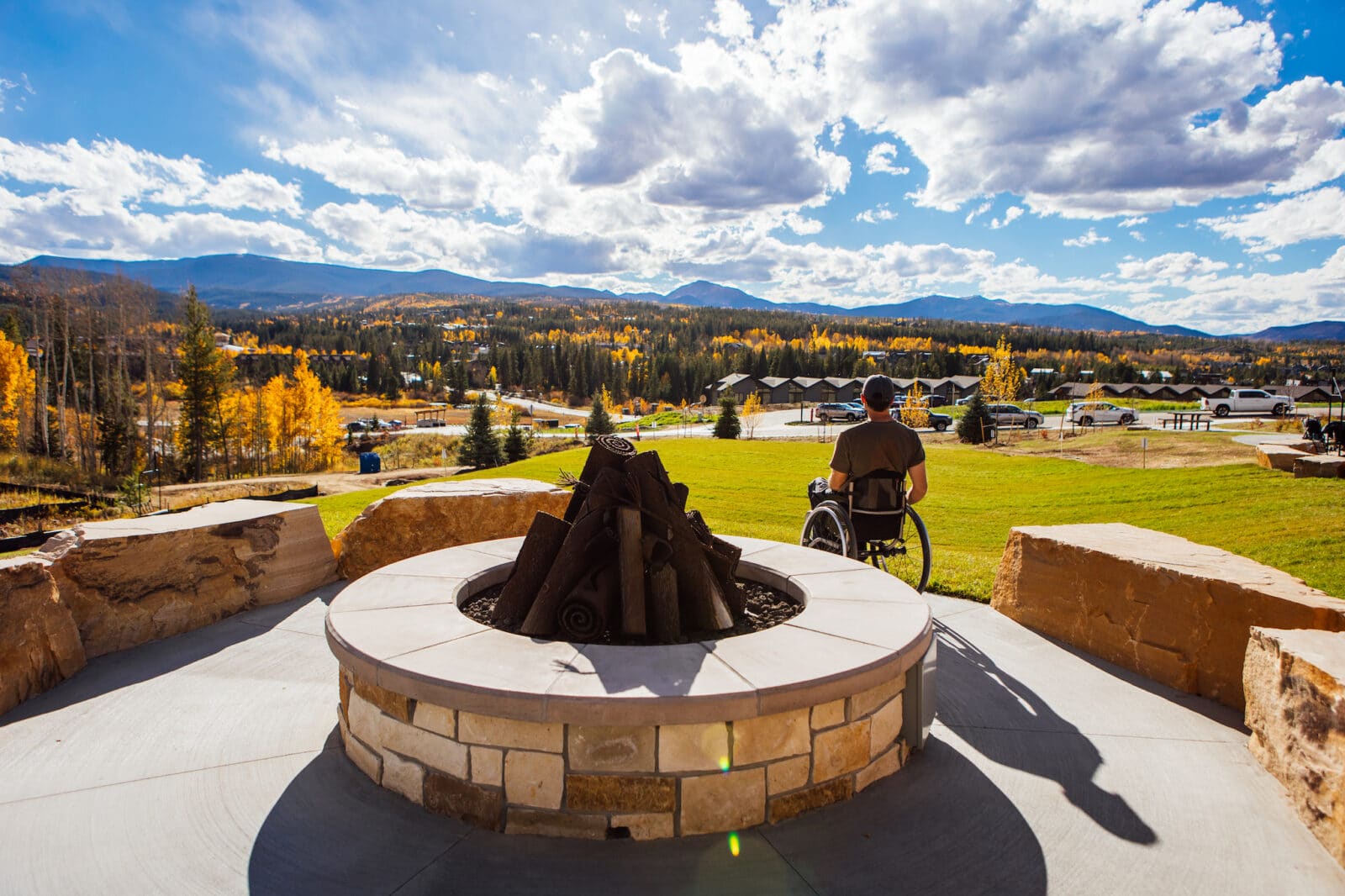 Stone gas fire pit and man in wheel chair admires the view from Idlewild Park
