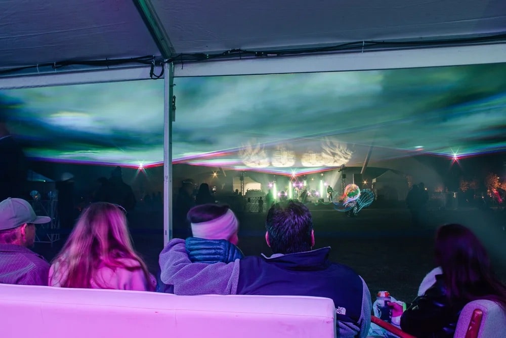 people watch the concert stage at the Aurora Borealis Festival in Colorado