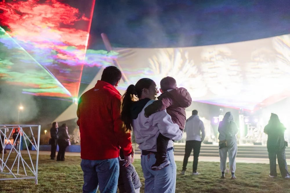 family looks out a light display on stage at the Aurora Borealis Festival in Colorado