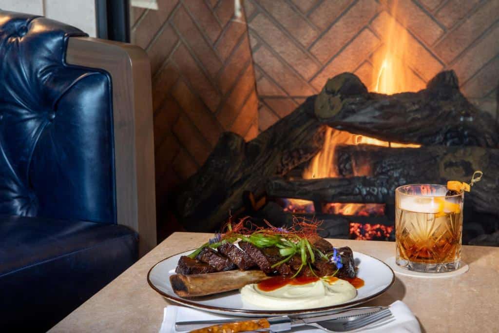 dining table beside a gas fireplace at The Benson Hotel in Aurora, Colorado
