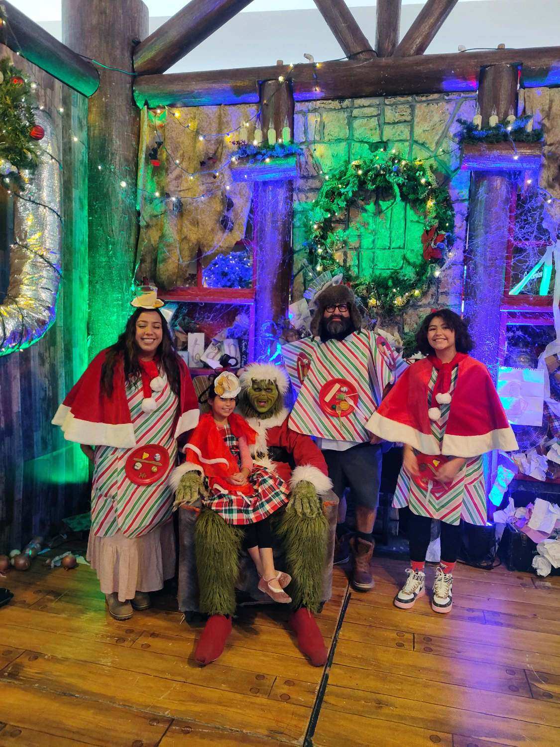 The Grinch poses for a picture with his helpers at Orchard Town Center